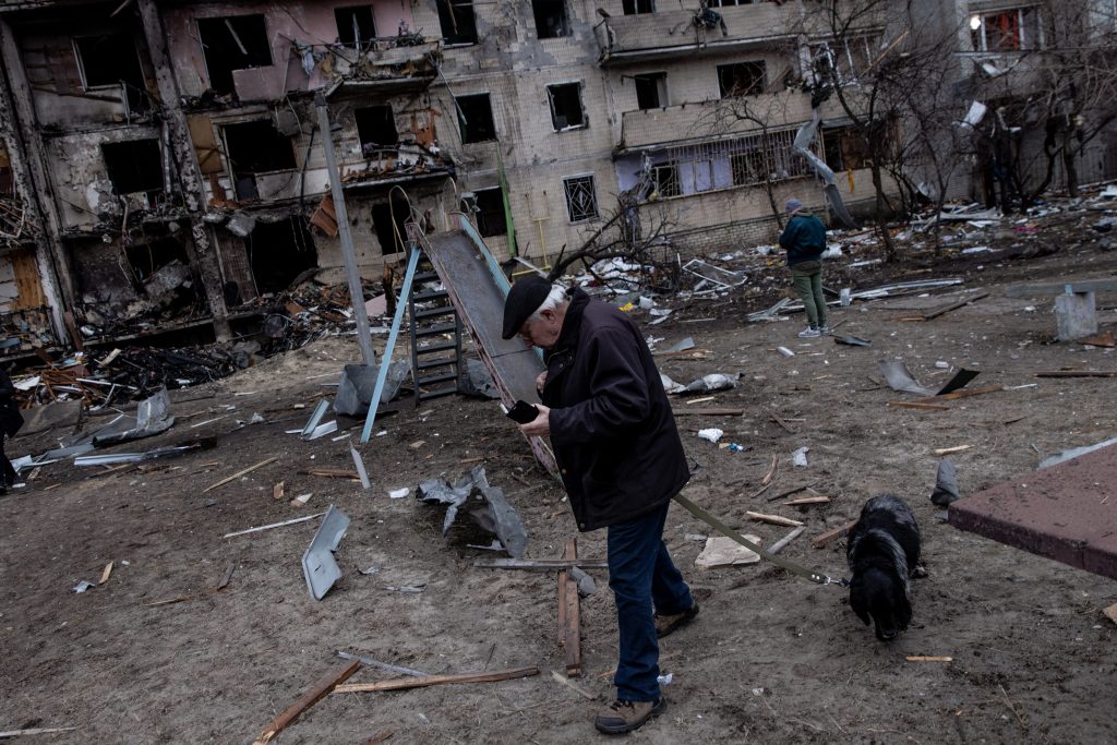 Un missile ha distrutto diversi palazzi in una zona residenziale di Kiev. Un uomo porta a passeggio il cane il giorno dopo (credits: Getty images)